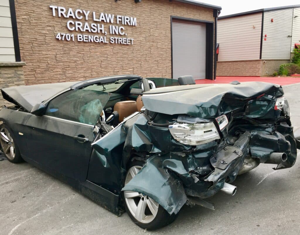 Exterior of the Tracy Law Firm\'s Dallas Crash Lab With A Newly Arrived Car That Suffered A Severe Rear End Collision That Seriously Injured the Backseat Passengers