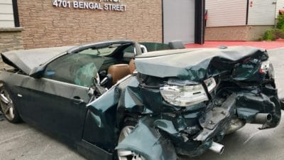 Exterior of the Tracy Law Firm’s Dallas Crash Lab With A Newly Arrived Car That Suffered A Severe Rear End Collision That Seriously Injured the Backseat Passengers